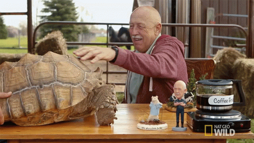 Man Petting Turtle With Nat Geo Wild Logo