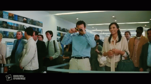 Man Photographing Woman In Crowded Area With Foreign Text GIF
