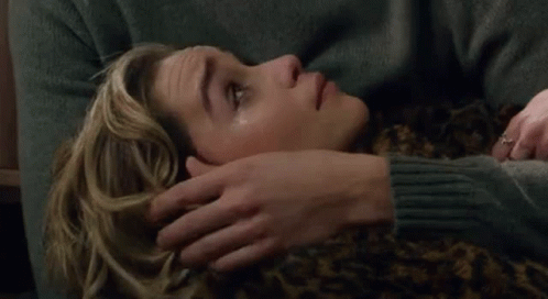 Man Placing Hand on Woman's Forehead on Couch