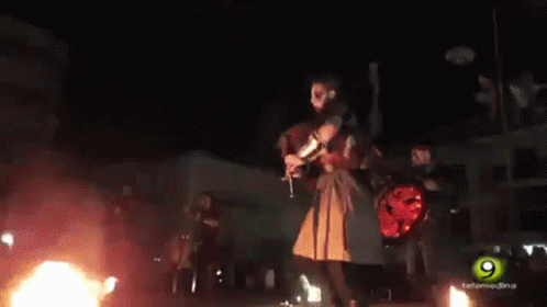 Man Playing Bagpipe in Front of Crowd