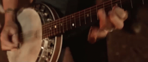 Man Playing Banjo and Guitar in Dark Room