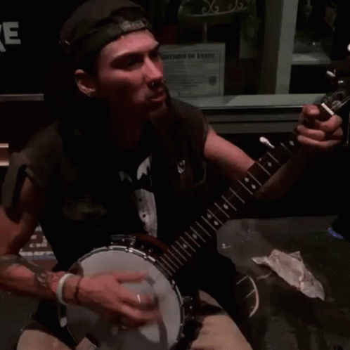 Man Playing Banjo in Front of Christmas Sign