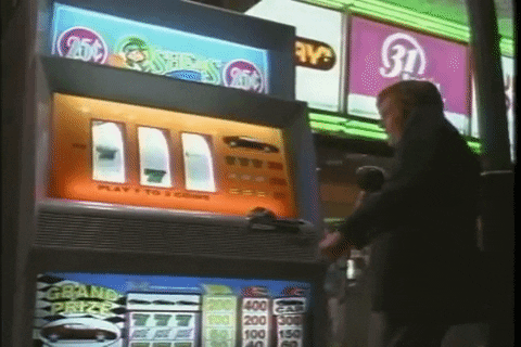Man Playing Coin Slot In Vegas Vacation GIF