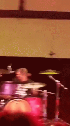 Man Playing Drums in Dark Room
