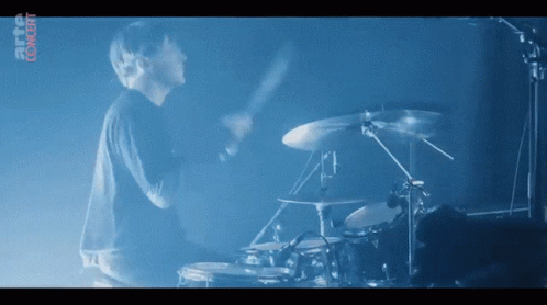 Man Playing Drums in Front of Digital Content Screen