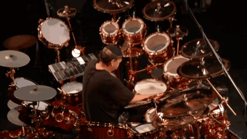 Man Playing Drums In Front Of Large Drum Set GIF