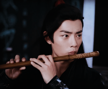 Man Playing Flute in Dark Room