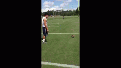 Man Playing Football on Field with Goal Post