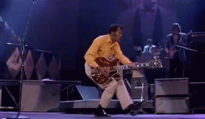 Man Playing Guitar and Dancing on Stage