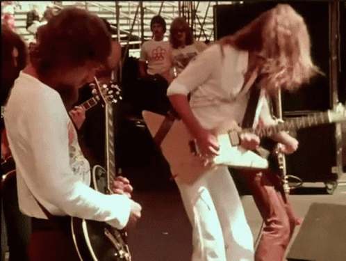 Man Playing Guitar for Crowd in BB Shirt