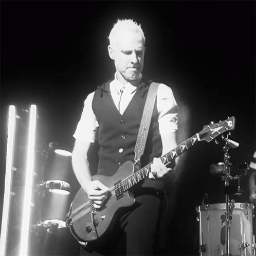 Man Playing Guitar in Dark Room