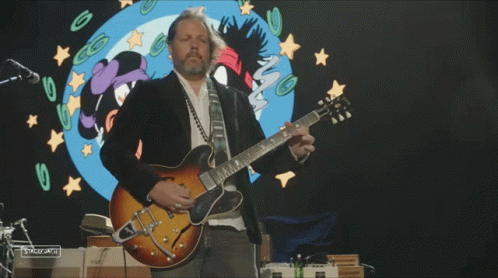 Man Playing Guitar in Front of Cartoon Girl