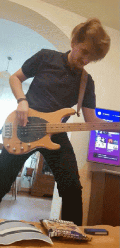 Man Playing Guitar In Front Of TV And M&Ms GIF