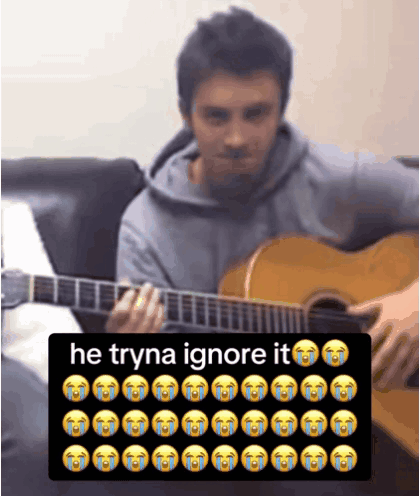 Man Playing Guitar Next to Keyboard Saying He Tryna Ignore It