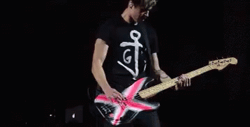 Man Playing Guitar on Stage Saying G
