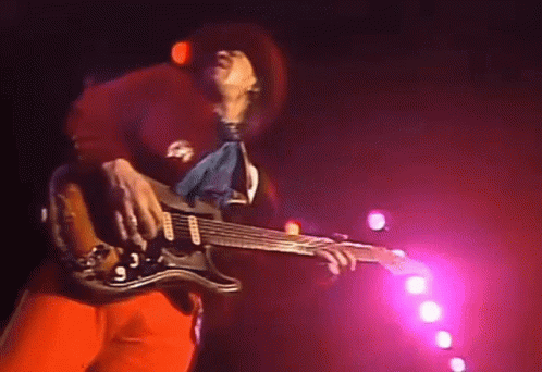 Man Playing Guitar On Stage With Pink Lights GIF