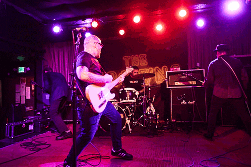 Man Playing Guitar With Exit Sign