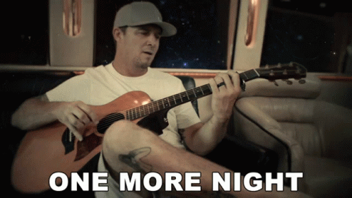Man Playing Guitar With One More Night Behind