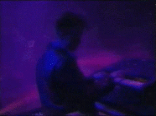 Man Playing Keyboard on Stage With Blue Light