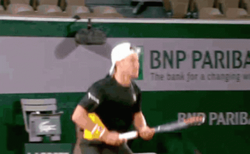 Man Playing Tennis in Front of BNP Pariba Ad