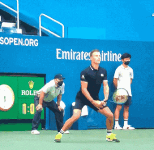 Man Playing Tennis in Front of Emirates Ad