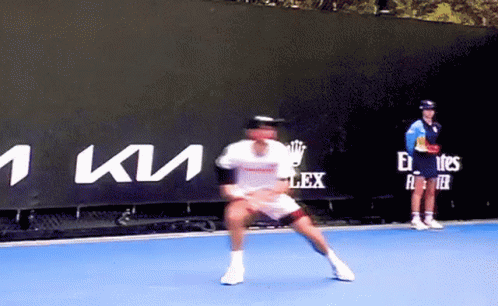 Man Playing Tennis in Front of Kia Sign