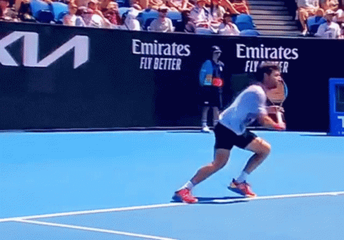 Man Playing Tennis on Court with Emirates Fly Better