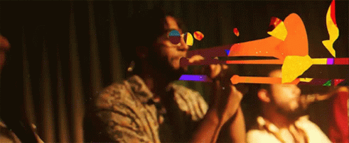 Man Playing Trumpet In Dark Room, Another Watches GIF