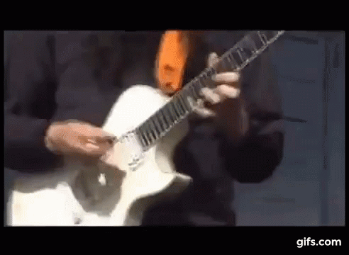Man Playing White Electric Guitar With Orange Tie