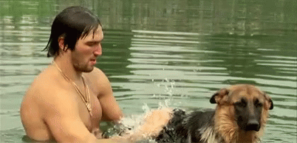 Man Playing With German Shepherd in Water
