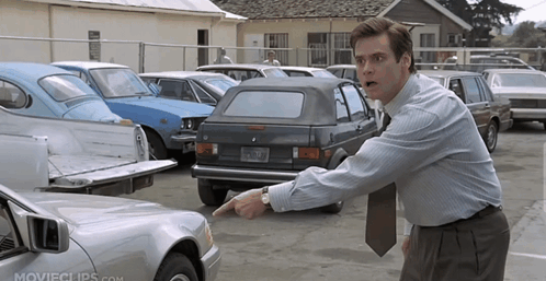 Man Pointing at Car in Parking Lot