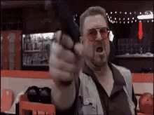Man Pointing Gun at Camera in Bowling Alley