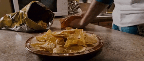 Man Pouring Cheese On Nacho GIF