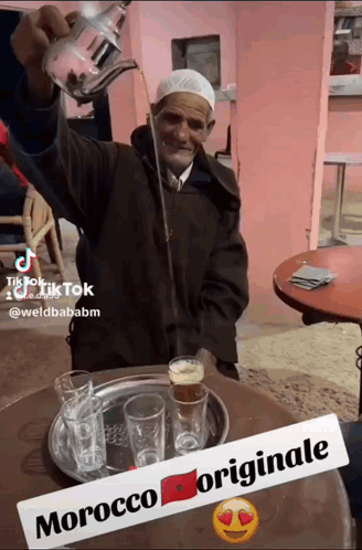 Man Pouring Drink From Teapot With Morocco Originale Sign