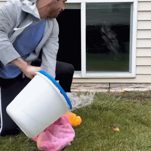 Man Pouring Water from White Bucket into Pink Towel