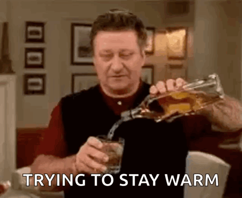 Man Pouring Whiskey Trying to Stay Warm