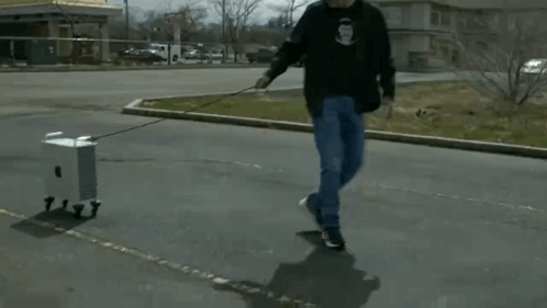 Man Pulling Small Box on a Leash