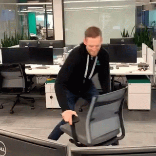 Man Pushing Chair in Office with Dell Monitor