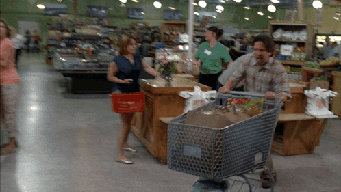 Man Pushing Shopping Cart Full of Groceries