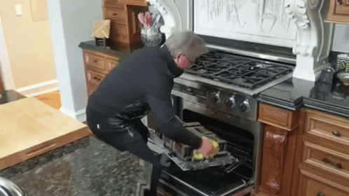 Man Putting Something in Oven in Kitchen