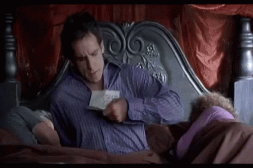 Man Reading Book in Bed Beside Woman