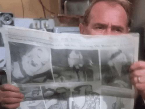 Man Reading Newspaper With Woman on Front