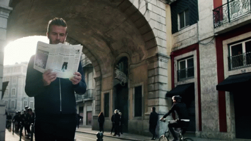 Man Reading Newspaper Woman Riding Bike