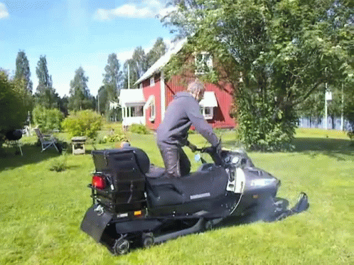 Man Riding A Snowmobile On The Grass GIF