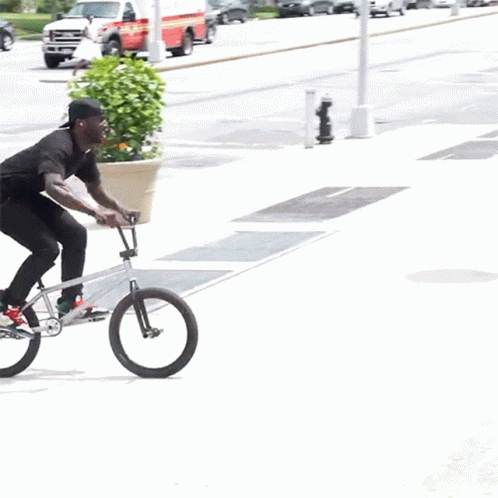 Man Riding Bike on Sidewalk Next to Staircase