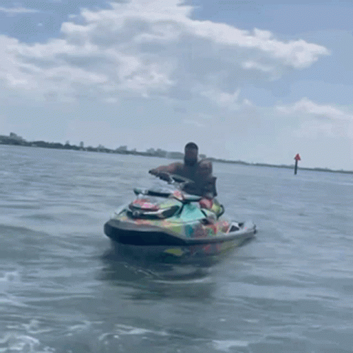 Man Riding Colorful Jet Ski in Water