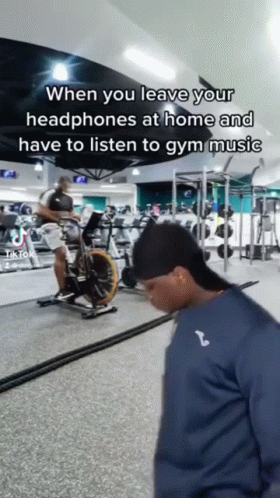 Man Riding Exercise Bike With Headphones