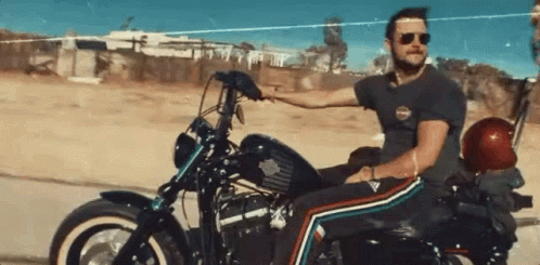 Man Riding Harley Davidson Motorcycle on Dirt Road