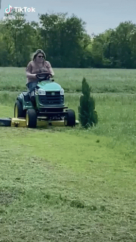 Man Riding Lawn Mower in Field