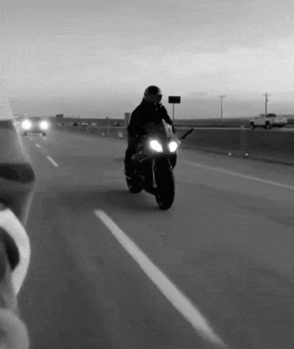 Man Riding Motorcycle Down Highway Black and White